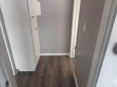 a hallway with white walls and a wood floor