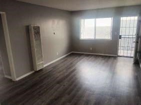 an empty living room with a hard wood floor