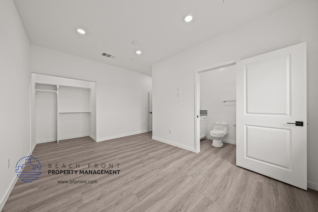 a white bathroom with white doors and a white toilet