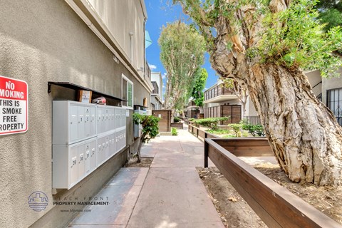 an alley between two apartment buildings with a no smoking sign on the wall