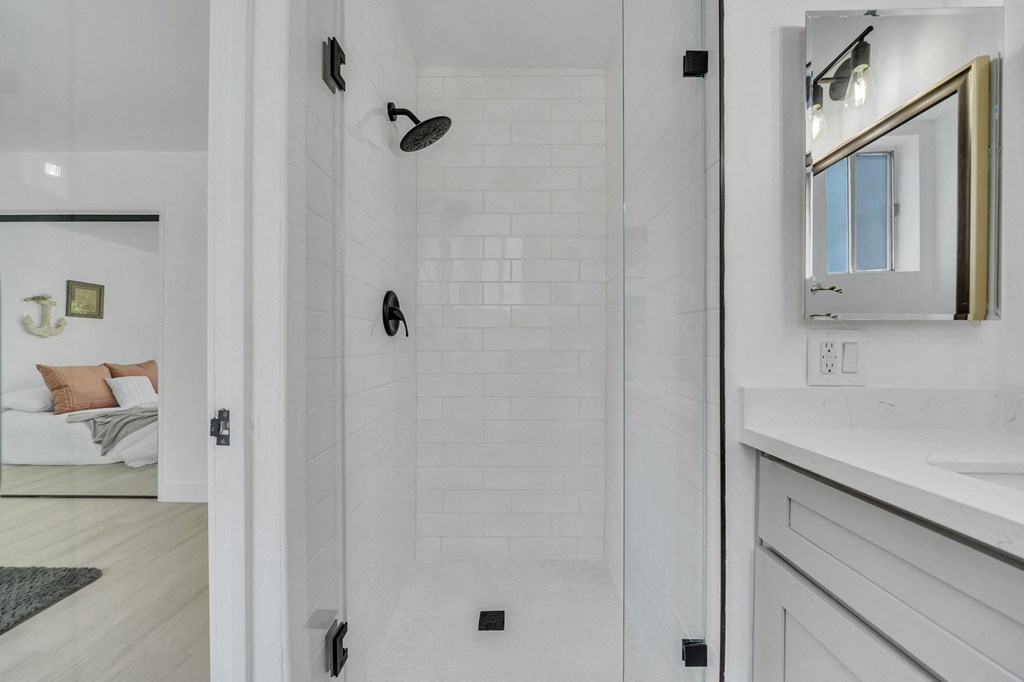 a white bathroom with a shower and a sink