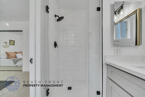 a white bathroom with a shower and a sink