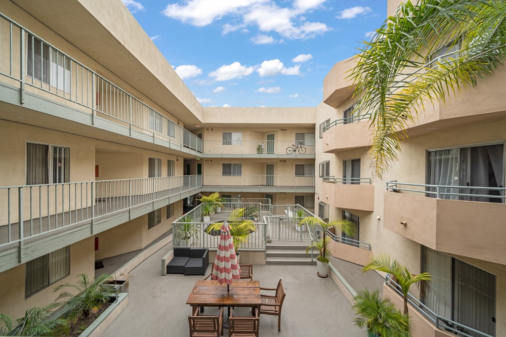 a courtyard with a table and chairs in the middle