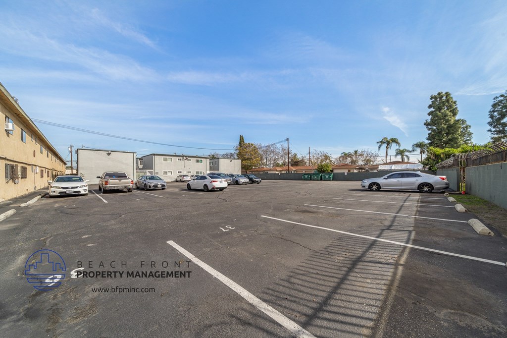 a parking lot with cars and a building on the side