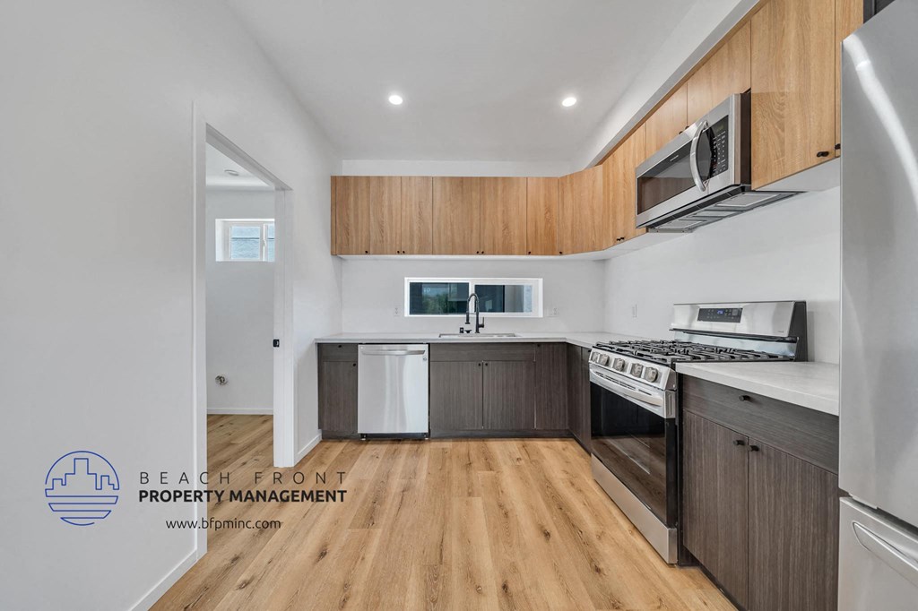 a kitchen with wooden cabinets and white appliances and a wooden floor