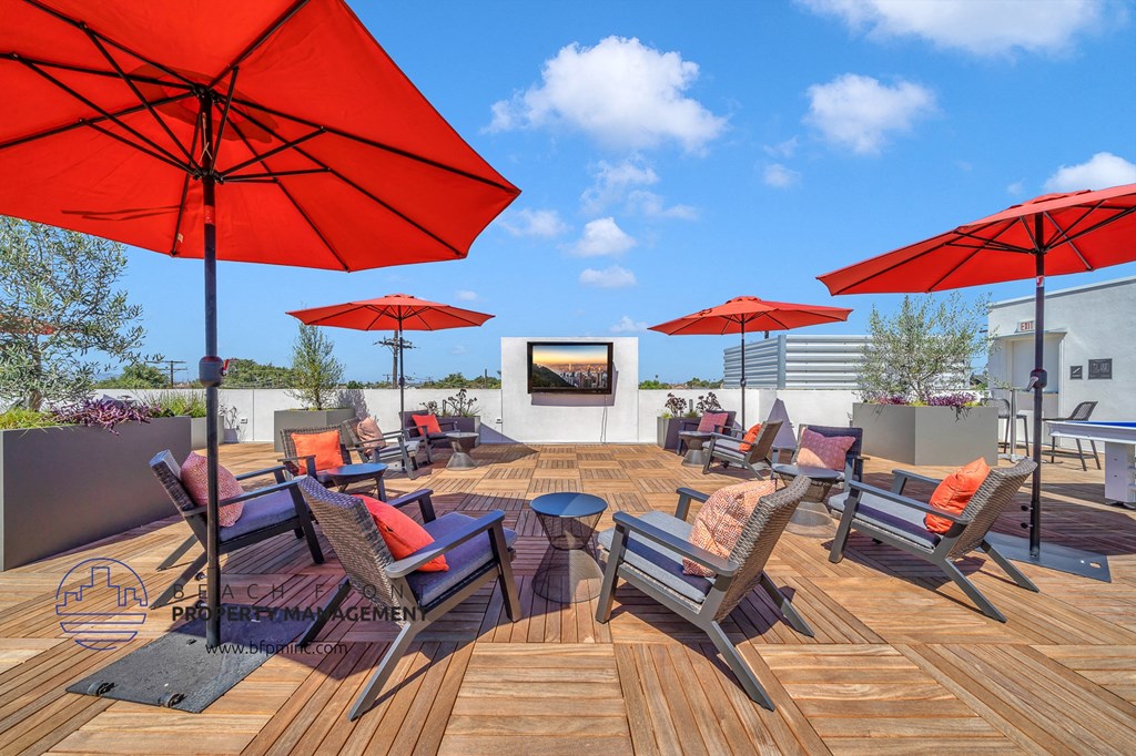 a rooftop patio with chairs and umbrellas and a tv