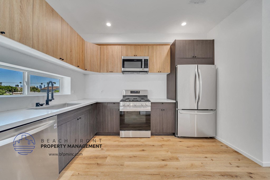 a white kitchen with wooden cabinets and stainless steel appliances