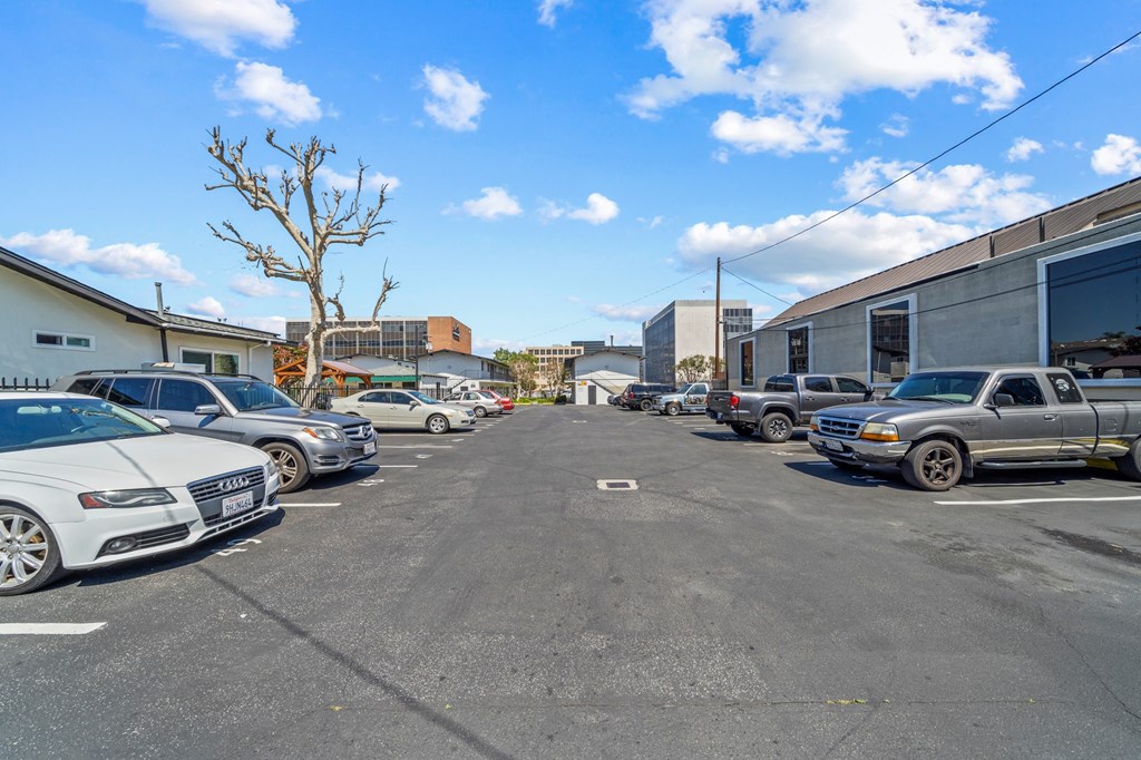 a parking lot filled with cars in front of a building