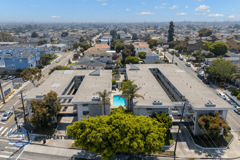 A bird's eye view of a city with buildings, roads, and a pool.