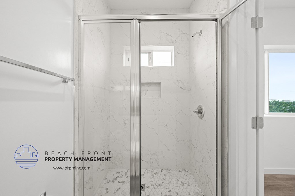 a walk in shower in a bathroom with a glass door