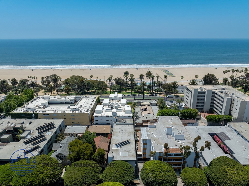 A beachfront cityscape with buildings, trees, and a beach.