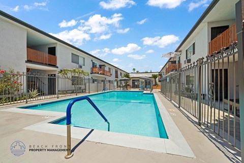 A swimming pool in a residential area with a blue metal handrail.