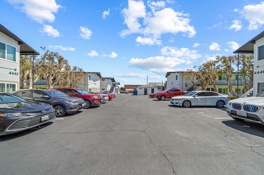 a parking lot with cars in front of apartment buildings