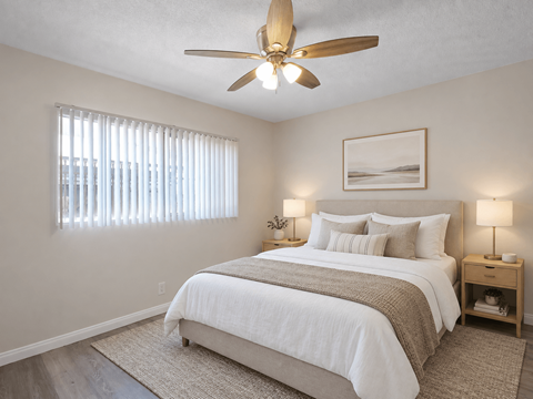 A bedroom with a large bed and a ceiling fan.
