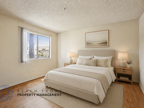 A well-lit bedroom with a large bed and a window overlooking a beach.