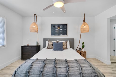 A bedroom with a large bed and a ceiling fan.