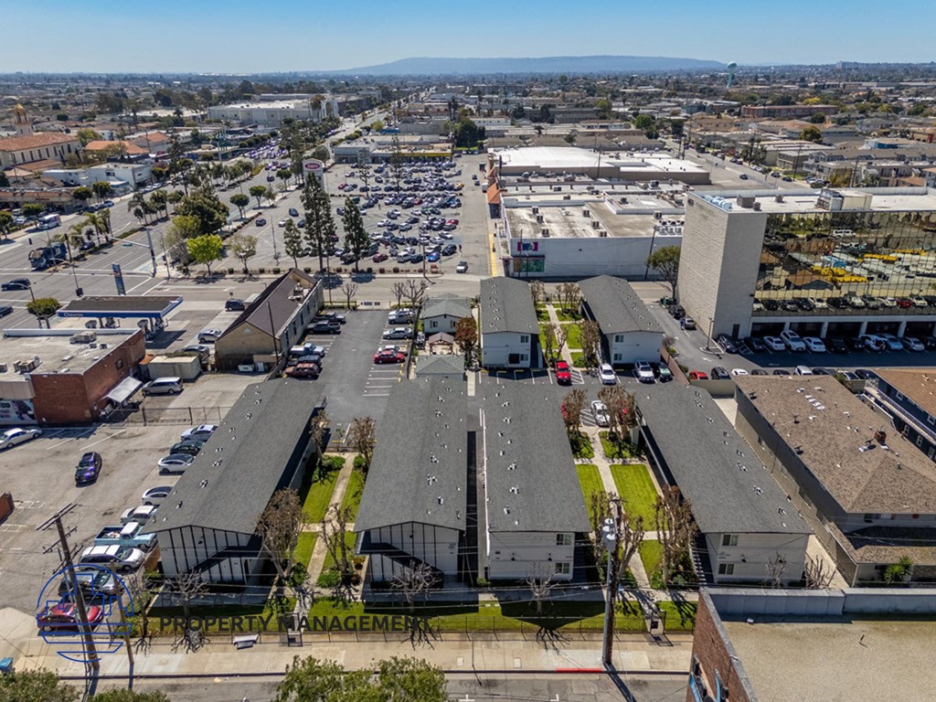an aerial view of a parking lot and rooftops of buildings