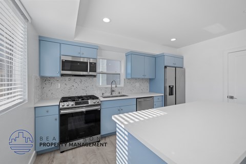 A kitchen with blue cabinets and a white countertop.