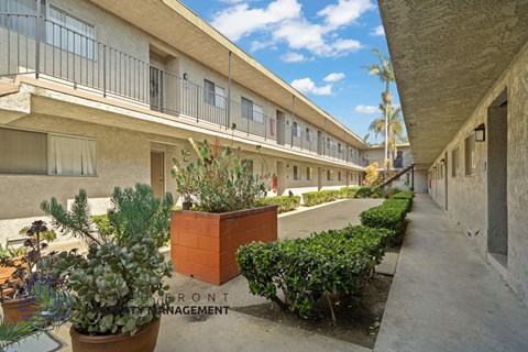 A courtyard with a brick planter and a sign that says Front Management.