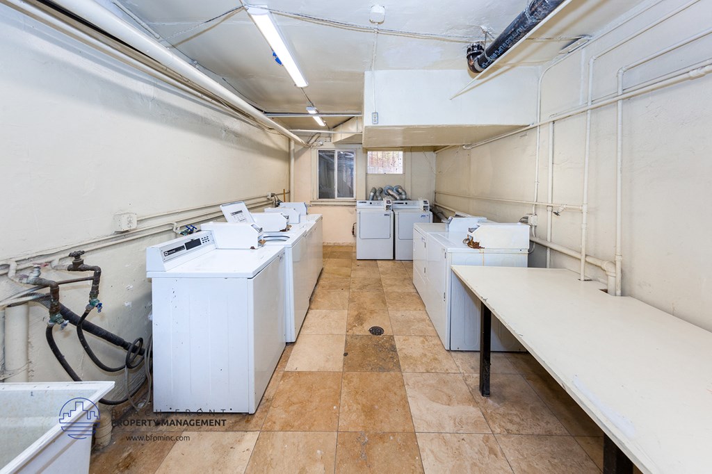 a room filled with white washing machines and sinks