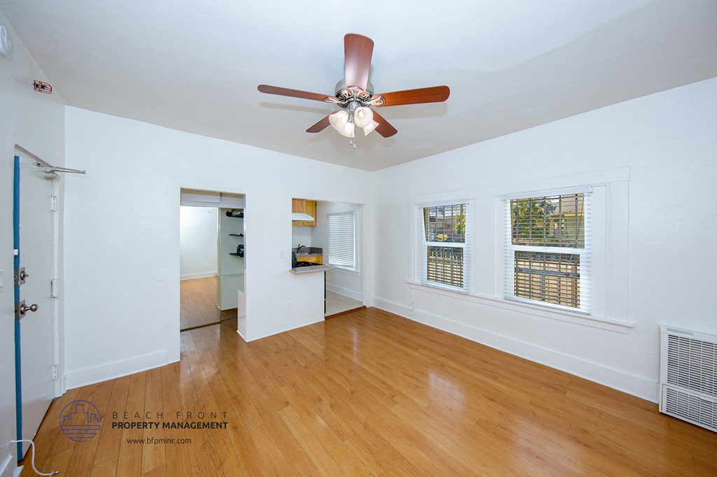 a living room with wood floors and a ceiling fan