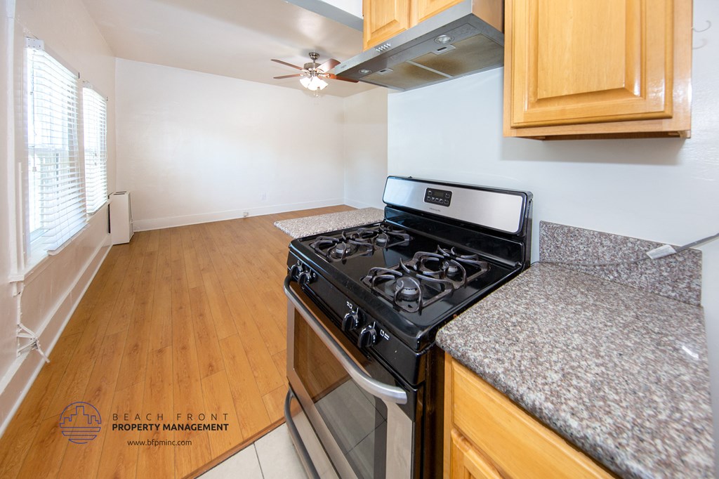 a kitchen with wood flooring and granite counter tops and a stove top oven