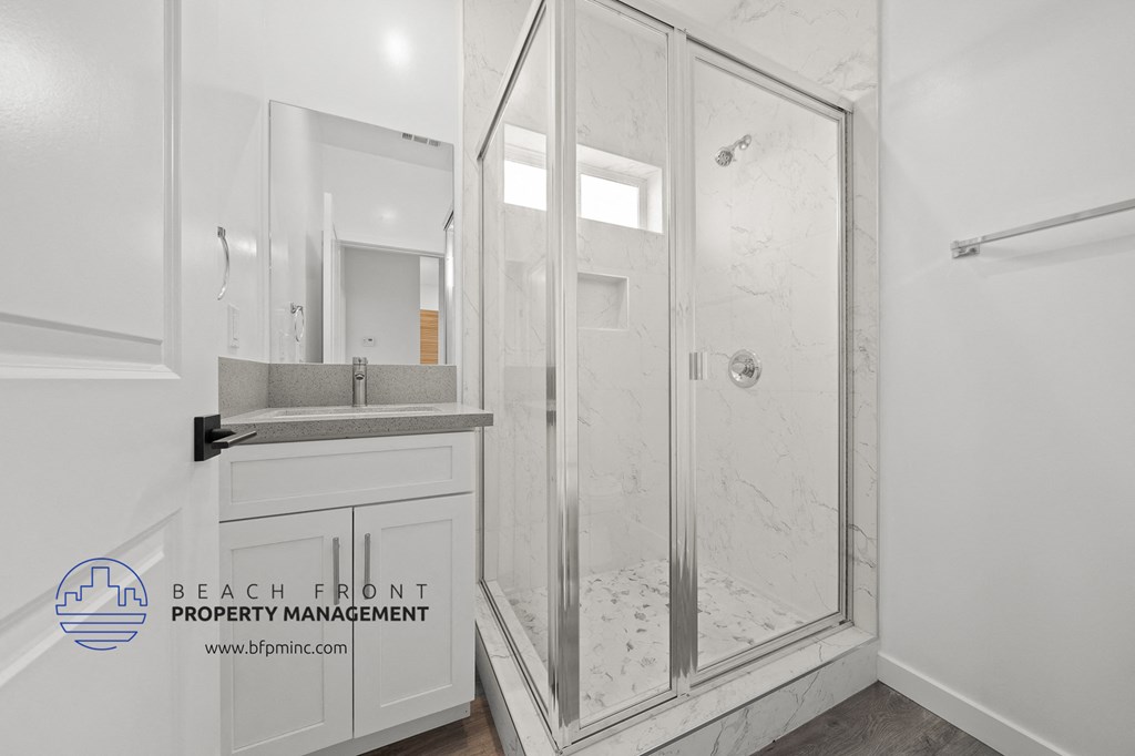 a white bathroom with a shower and a sink