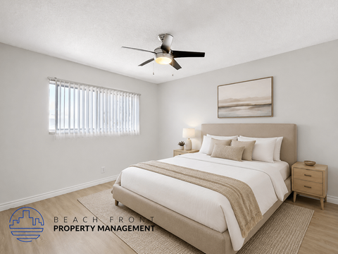A well-lit bedroom with a large bed and a ceiling fan.