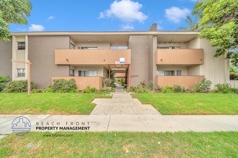 a building with a sidewalk and grass in front of it