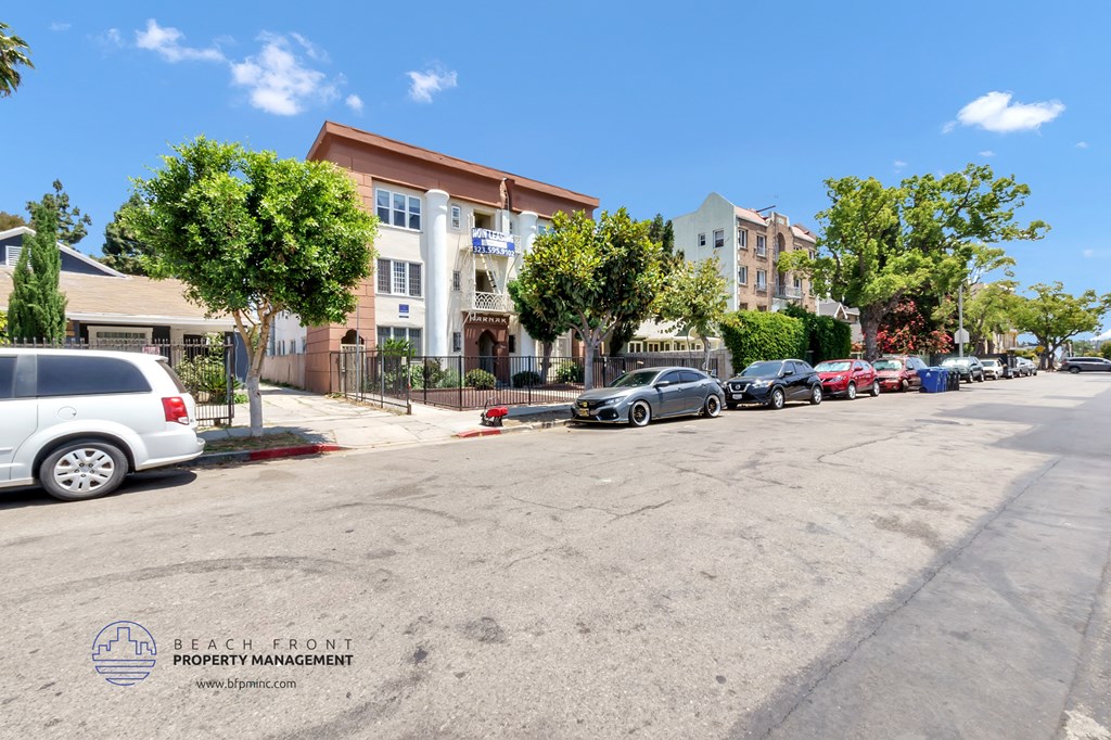 a parking lot with cars parked in front of apartment buildings