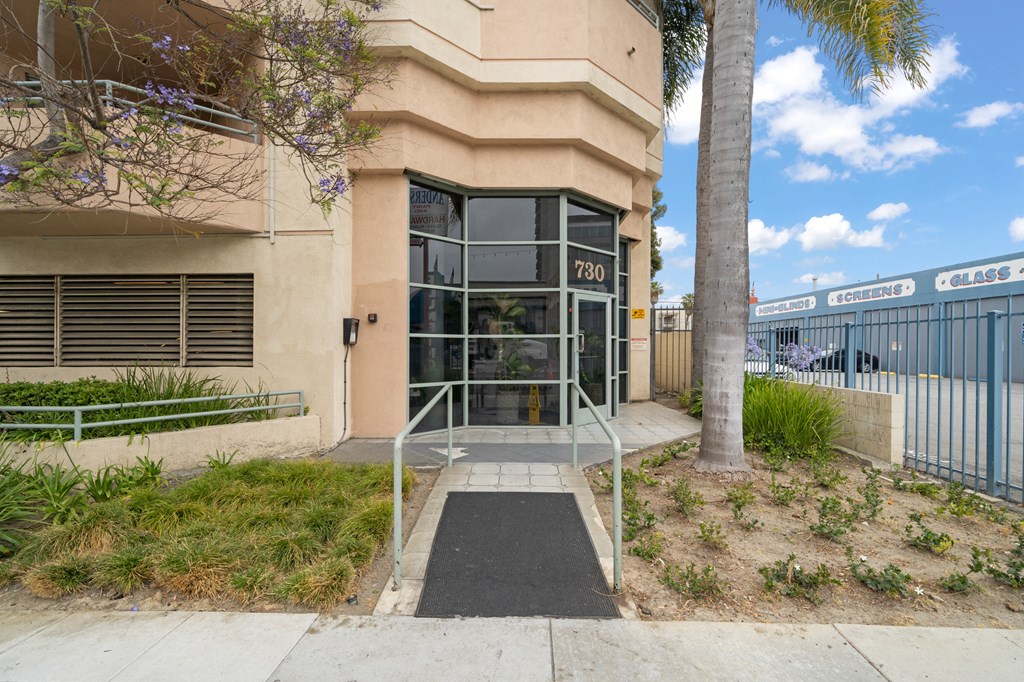 a building with a glass door and a sidewalk in front of it