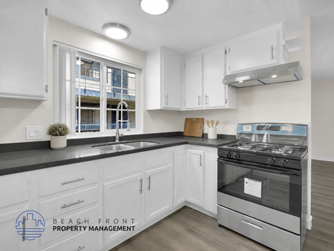 A kitchen with white cabinets and a stove top oven.