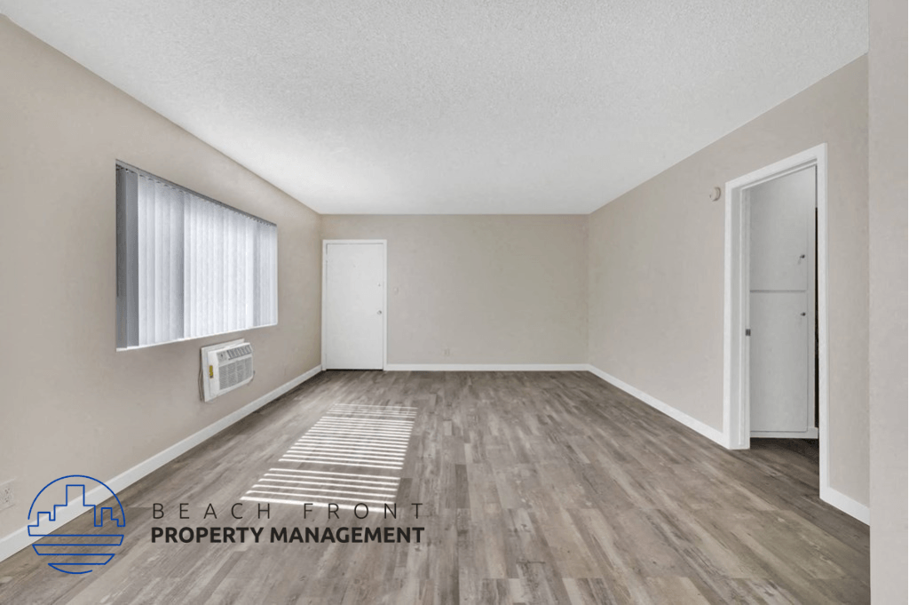 an empty room with hardwood flooring and white walls