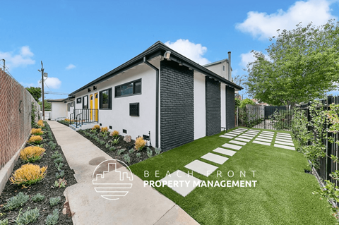 a home with a lawn and a sidewalk in front of it