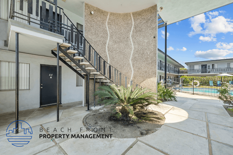 a spiral staircase leading up to a building with a plant in front of it