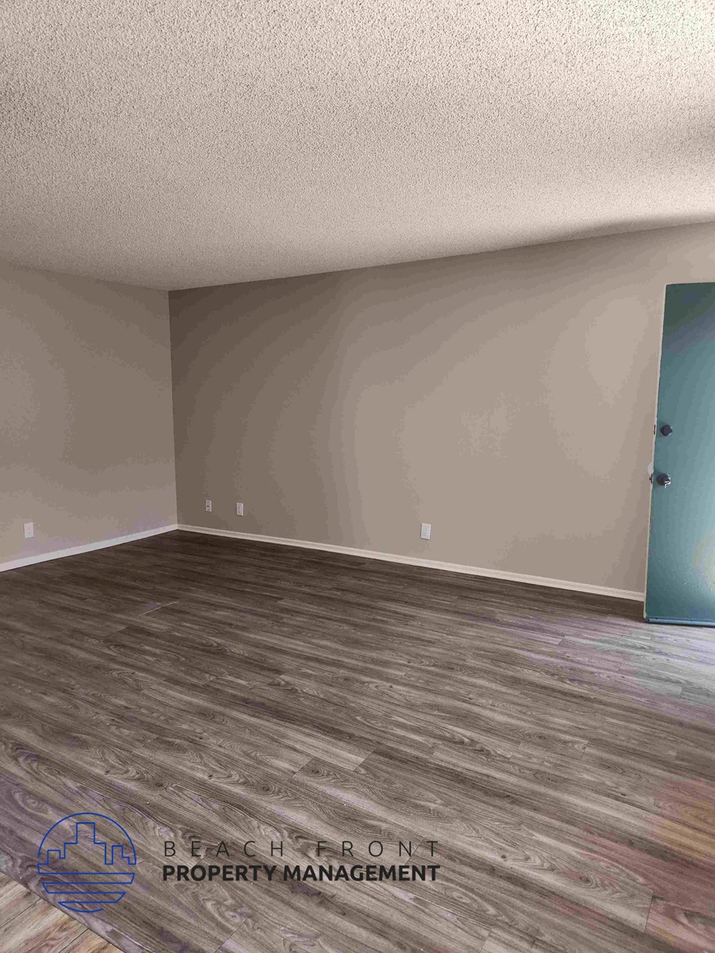 A room with wooden flooring and a blue door.