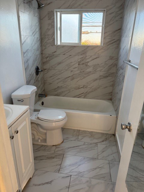 A bathroom with a tub, toilet and sink.
