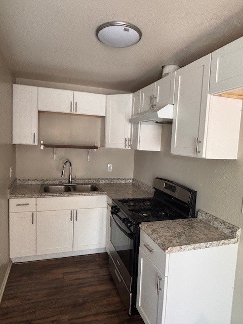 A kitchen with white cabinets and a granite counter top.