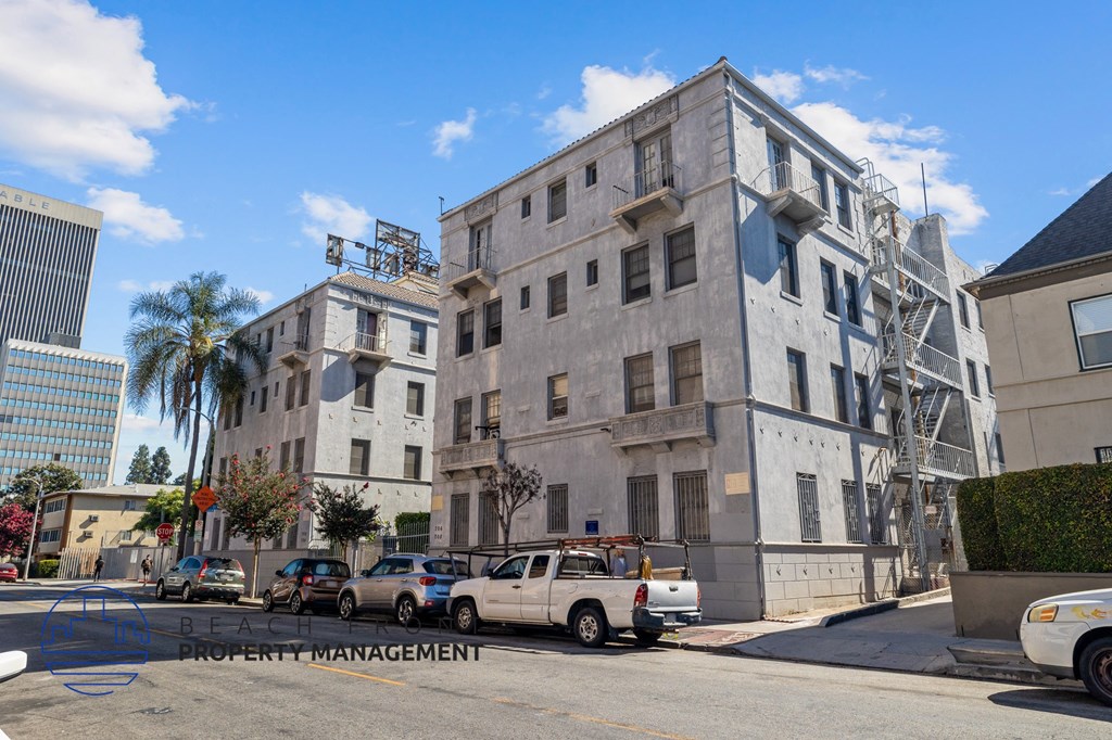 an old building on the corner of a street with parked cars