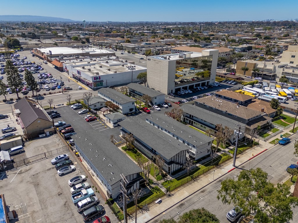 an aerial view of a city with buildings and cars parked in a parking lot