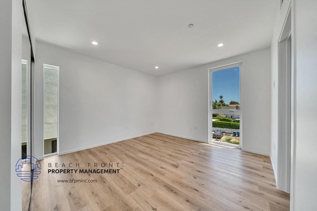 a living room with a hardwood floor and a door to a balcony