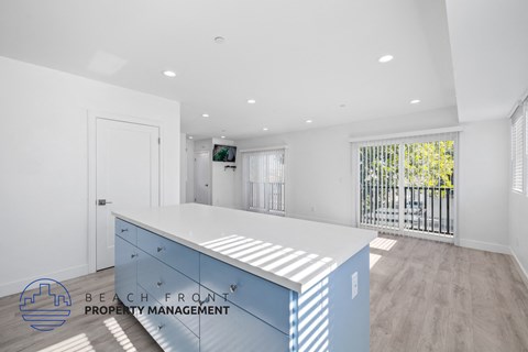 A spacious office with a desk and a balcony with a view of the outside.