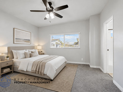 A bedroom with a large bed and a ceiling fan.