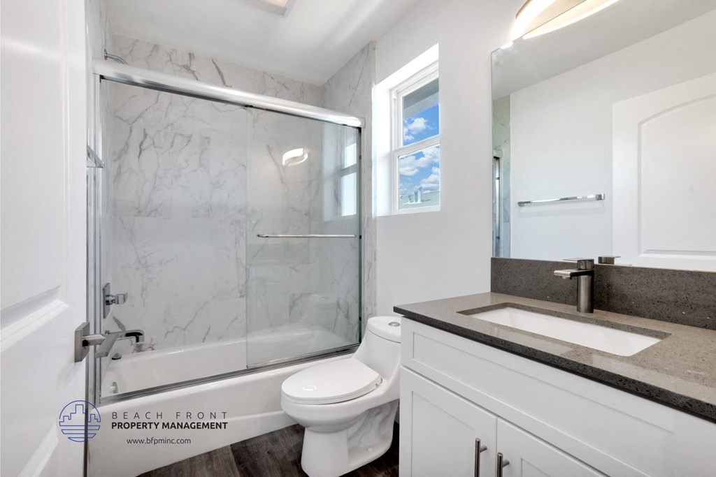 a bathroom with a shower and a sink and a toilet