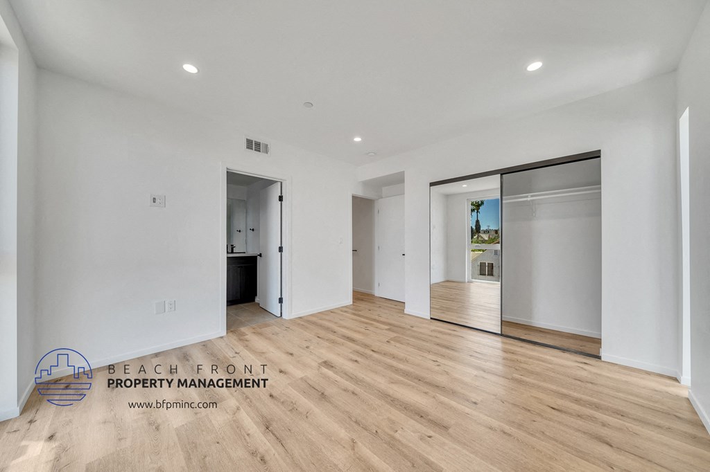 a renovated living room with white walls and wood flooring