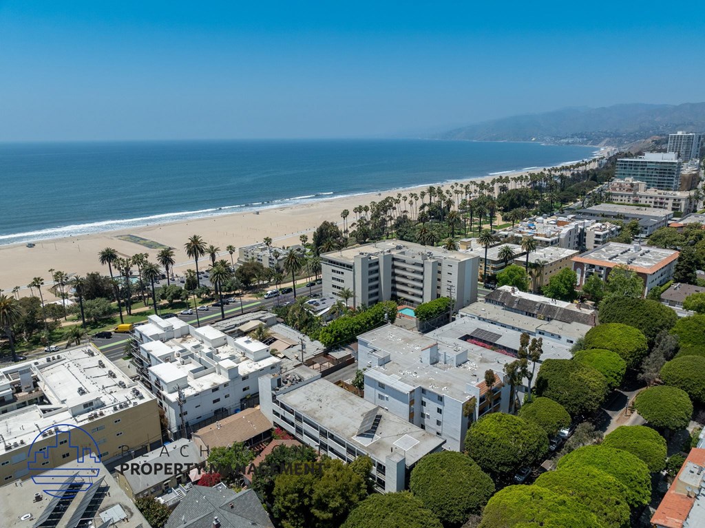 A beachfront property with a clear blue sky and ocean in the background.
