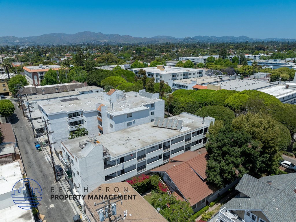 An aerial view of a building complex with trees and other buildings in the background.