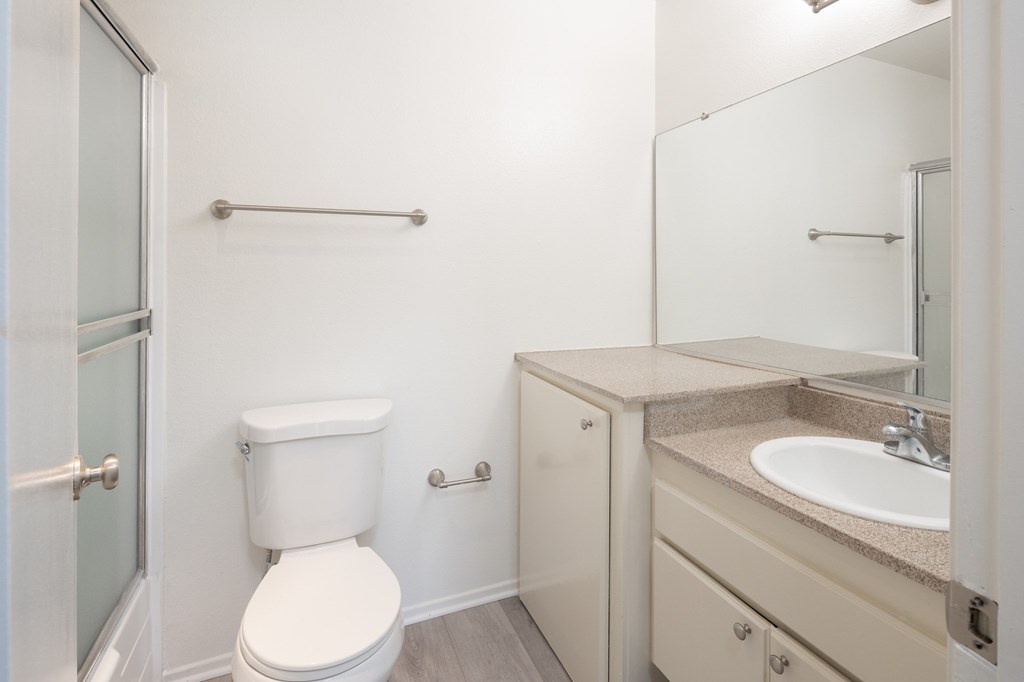 A white toilet sits next to a sink in a bathroom.