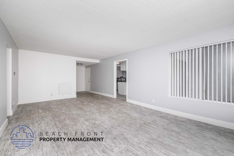 A spacious room with a logo for Beach Front Property Management on the floor.