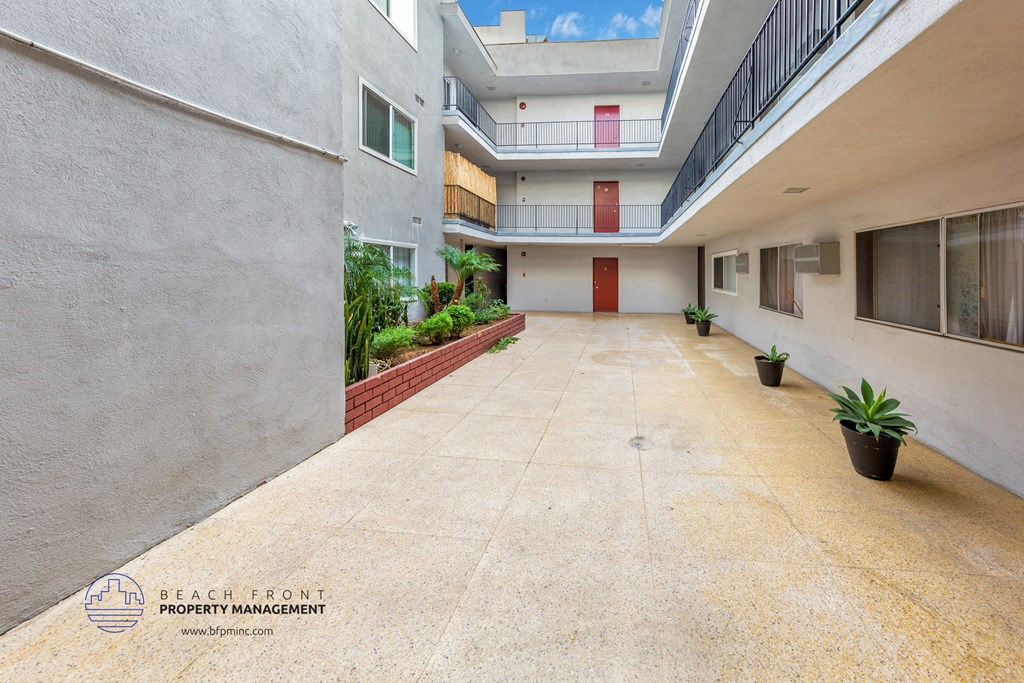an empty courtyard of an apartment building with potted plants